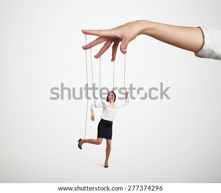 womans hand manipulating the small puppet over light grey background