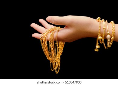 Woman's Hand With Many Different Gold Jewelry On Black Background