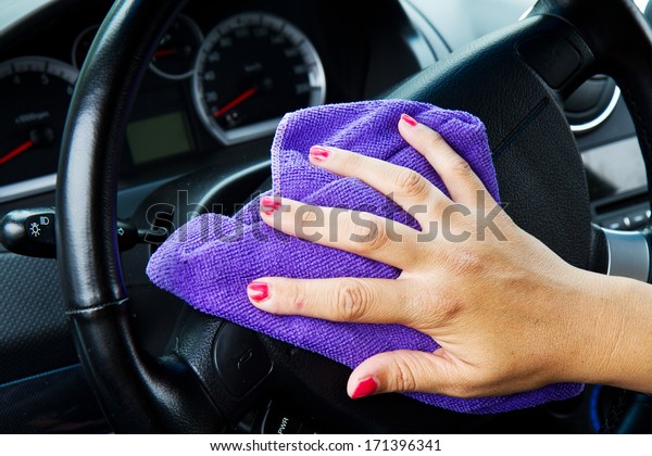Woman's hand with microfiber cloth polishing wheel of a
car 
