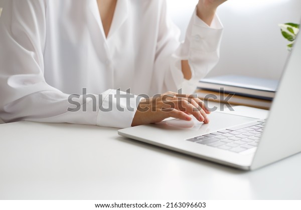 Woman\'s hand is moving a finger on\
touchpad on laptop to move cursor to the desired\
position.