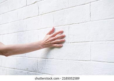 Woman's hand on the background of a white brick wall. A woman touches the old wall of the monastery. - Shutterstock ID 2185052589