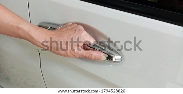 A woman\'s hand opening\
the car door