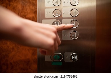 Woman's Hand Operating Old Elevator Buttons