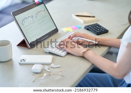 A woman's hand operating a tablet PC in the room