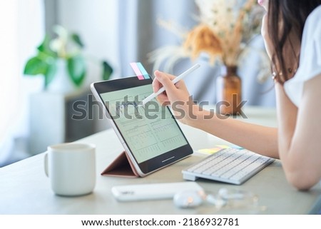 A woman's hand operating a tablet PC in the room