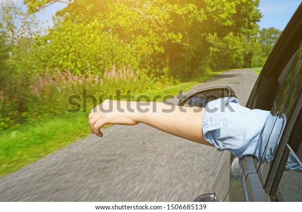 Woman\'s hand outside car window. Summer\
vacations concept.