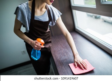 Woman's Hand In Pink Rubber Protective Glove With Dry Rag Wiping Wooden Window Sill From Dust. Early Spring Cleaning Or Regular Clean Up. Maid Cleans House.