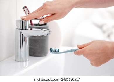 Woman'S Hand Placed Toothbrush Under Tap For Oral Hygiene