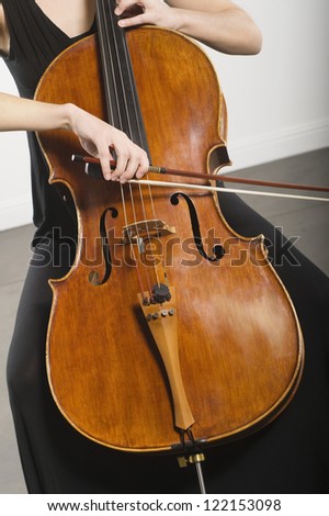 Woman's hand playing cello classical music instrument