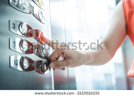 Woman's hand presses the elevator button