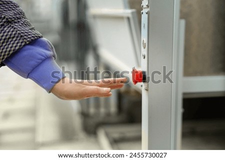 A woman's hand presses the red button to call for help