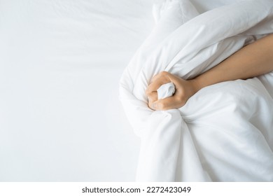 Woman's hand pulling white sheet in orgasm Sex concept