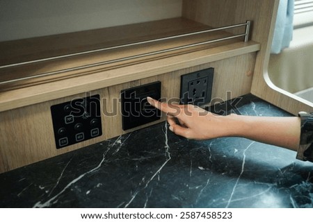 Woman's hand push a switch to opening air condition in modern interior style of the campervan or motorhome.