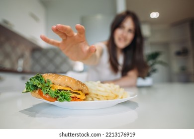 A Woman's Hand Reaches For A Big Juicy Burger.