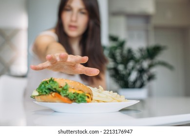 A Woman's Hand Reaches For A Big Juicy Burger.