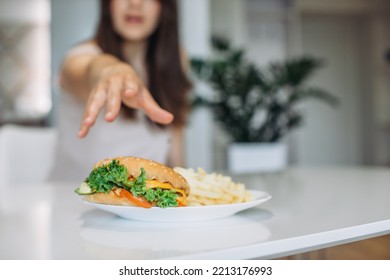 A Woman's Hand Reaches For A Big Juicy Burger.