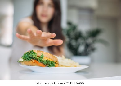 A Woman's Hand Reaches For A Big Juicy Burger.