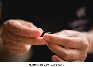 Woman's hand sewing fabric with sewing equipments - Shutterstock ID 635380919
