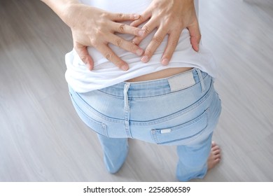 Woman's hand She is caught at the waist and her back is painful at the back in the park. Cause of the exercise. - Shutterstock ID 2256806589