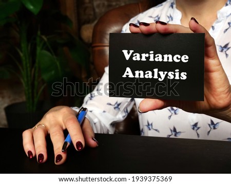 Woman's hand showing black business card with phrase Variance Analysis - closeup shot on grey background
