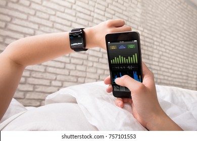 Woman's Hand Showing Heart Rate On Smart Watch And Cell Phone