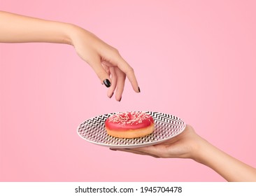 Womans Hand Takes Tasty Donut On Pink Background. Mockup Template For Bakery