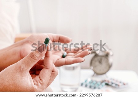 Woman's Hand Taking an Antibiotic Pill as Part of Long-term Antibiotic Therapy in the Treatment of Bacterial Infections