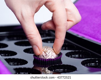 Woman's Hand Taking The Last Chocolate Candy In The Box