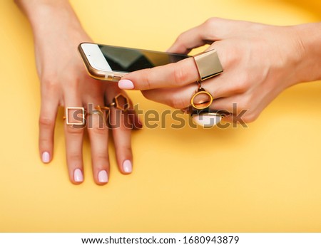 womans hand taking picture of her new manicure with fashion jewellery on her phone, girls stuff concept closeup
