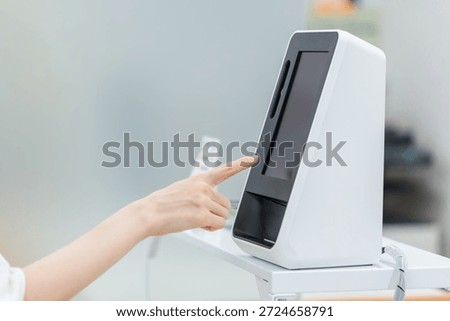 A woman's hand touching a touch panel machine (tablet register）