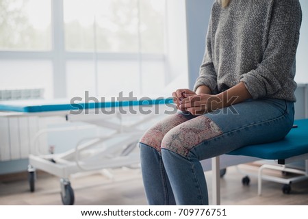 Woman's hand waiting for doctor in hospital feeling worried.