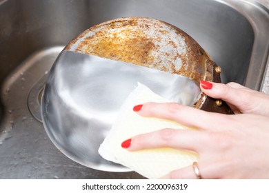 Woman's Hand Washing Only Half Of A Burnt Frying Pan