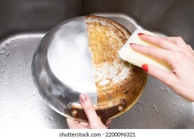 Woman's Hand Washing Only Half Of A Burnt Frying Pan