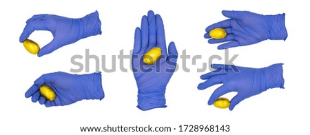 Woman's hand wearing blue medical examination glove holding or placing a golden wrapped egg in various poses.  Isolated on a white background.  No skin