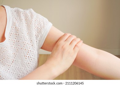 Woman's Hand In White T-shirt Touch Her Upper Arm , Arm Pain And Muscle Injury Concept