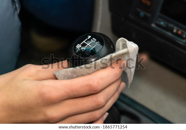 Woman\'s hand wipes the lever, the car\
selector with a napkin close-up. Dirty\
napkin
