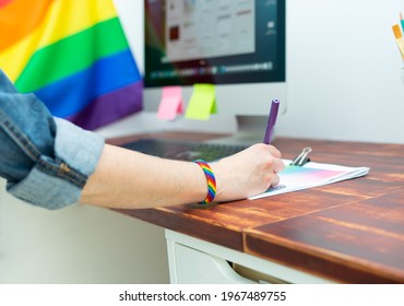 Woman's Hand Working In Office With LGBT Decor And Accessories. Cultura LGBTQIA