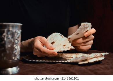 Woman's Hands Breaking Unleavened Bread For Communion For Easter With Silver Dish And Chalice