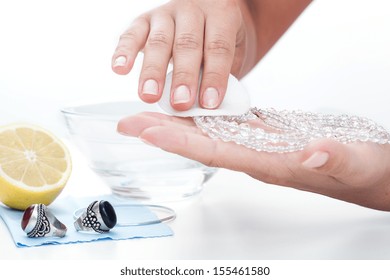 Woman's Hands Cleaning Jewellery With A Lemon Juice