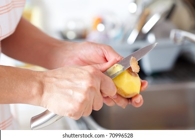 Woman's hands closeup, peeling potatoes in the kitchen