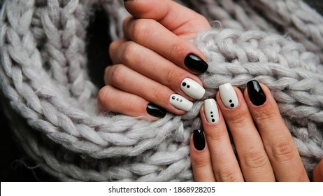 Woman's hands with a colorful patterns on the nails. 2021 colors trend. Top view. A place for text. Cozy winter design.