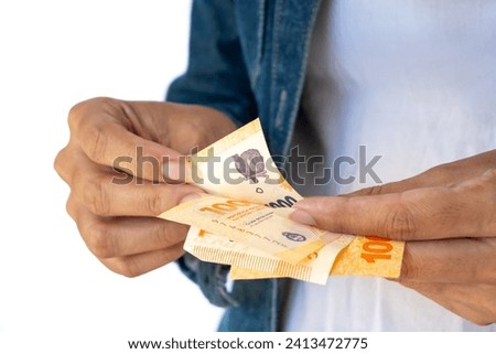 Woman's hands counting bills of one thousand Argentine pesos.