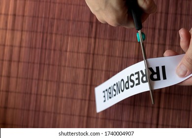 Woman's Hands Cut With Scissors The Word Printed On A Piece Of Paper: Irresponsible