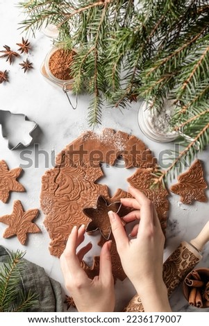 Woman's hands cut shapes and make cookies. Making Christmas cookies. Top view from above, flat lay
