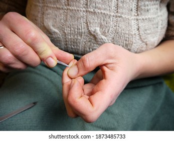 woman's hands doing an at home manicure with nail scissors removing cuticles - Shutterstock ID 1873485733