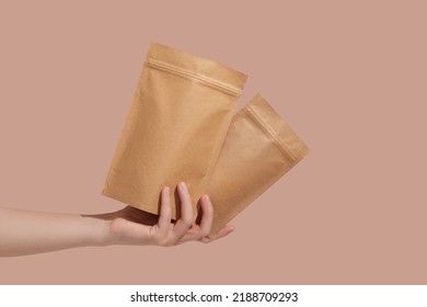 Woman's hands hold cardboard packages for tea or snacks on a beige background. Tea branding and packaging mockup. High quality photo - Shutterstock ID 2188709293