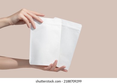 Woman's hands hold cardboard packages for tea or snacks on a beige background. Tea branding and packaging mockup. High quality photo - Shutterstock ID 2188709299