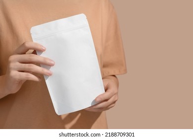 Woman's hands hold cardboard packages for tea or snacks on a beige background. Tea branding and packaging mockup. High quality photo - Shutterstock ID 2188709301