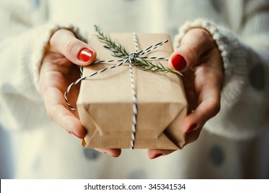 Woman's Hands Hold Christmas Or New Year Decorated Gift Box. Toned Picture