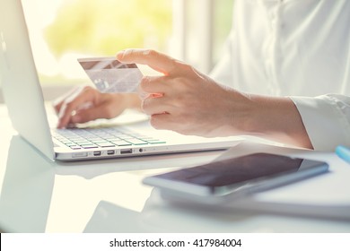 Woman's Hands Holding A Credit Card And Using Laptop For Online Shopping